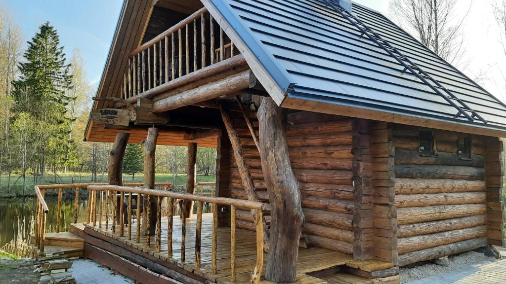 a log cabin with a balcony and a roof at Raistiko sauna cabin / Raistiko saunamaja 