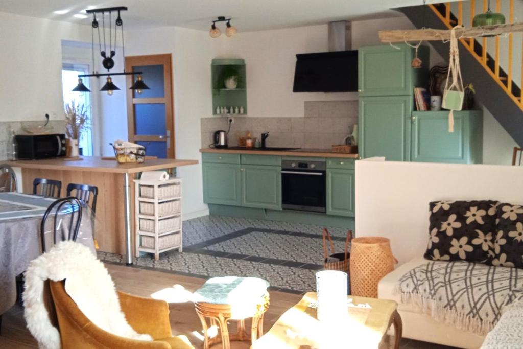 a kitchen and living room with green cabinets at La Osmonière - Maison 6 personnes - Tout inclus in Saint-Méloir-des-Ondes