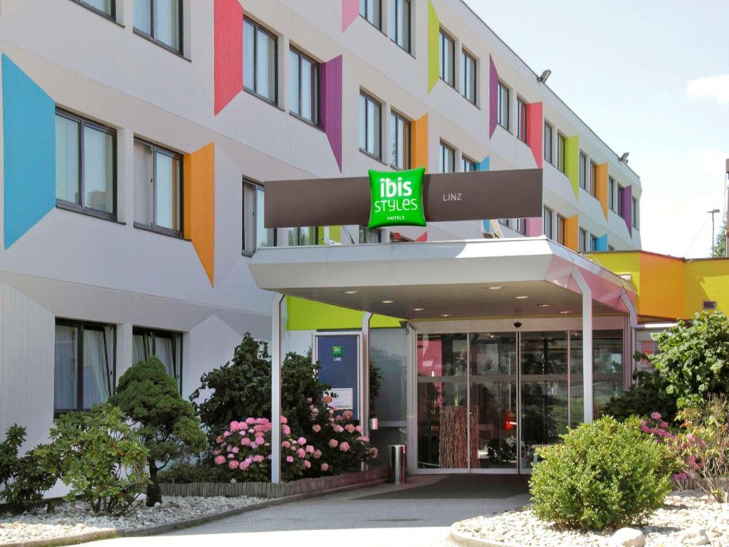 a building with a bus stop sign in front of it at Ibis Styles Linz in Linz
