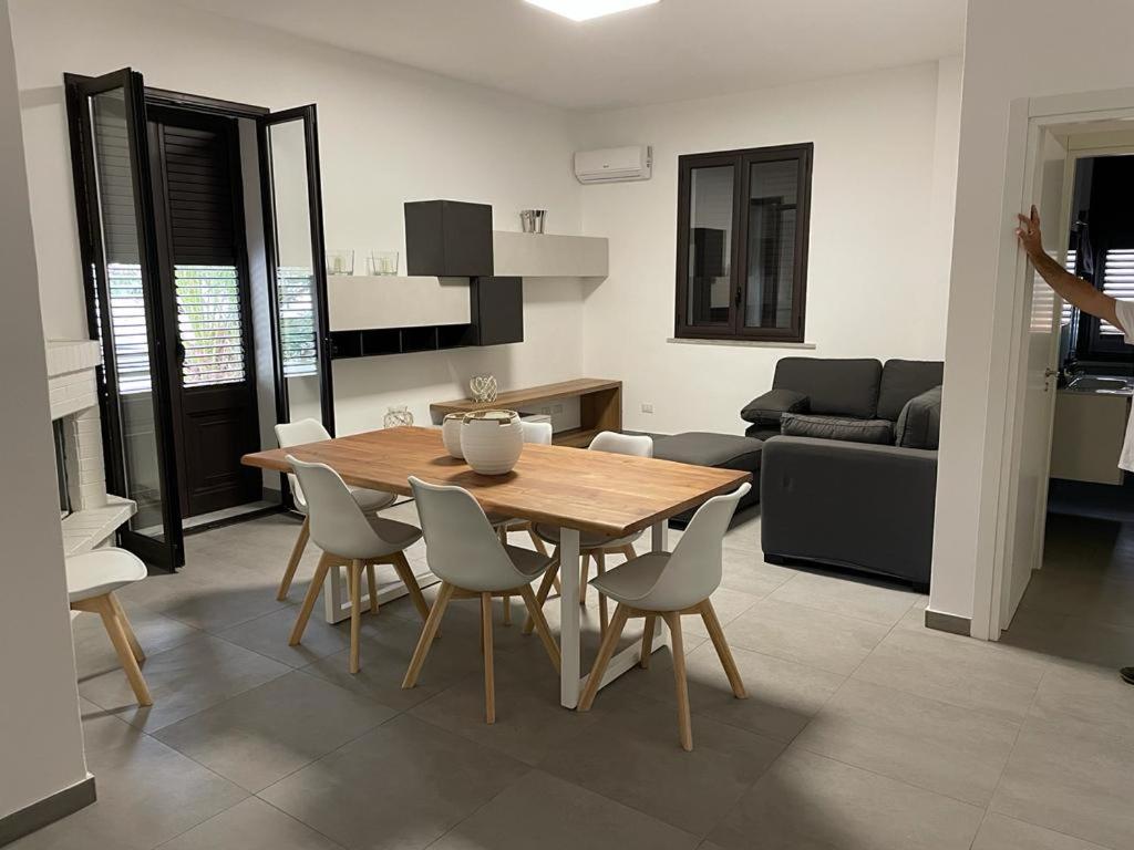Il comprend une cuisine et une salle à manger avec une table et des chaises en bois. dans l'établissement Villa da "Giacomino l'Americano", à Cinisi