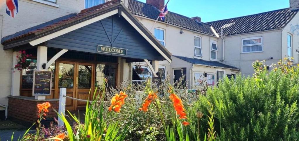 a restaurant with flowers in front of a building at The Bacchus Hotel in Sutton on Sea