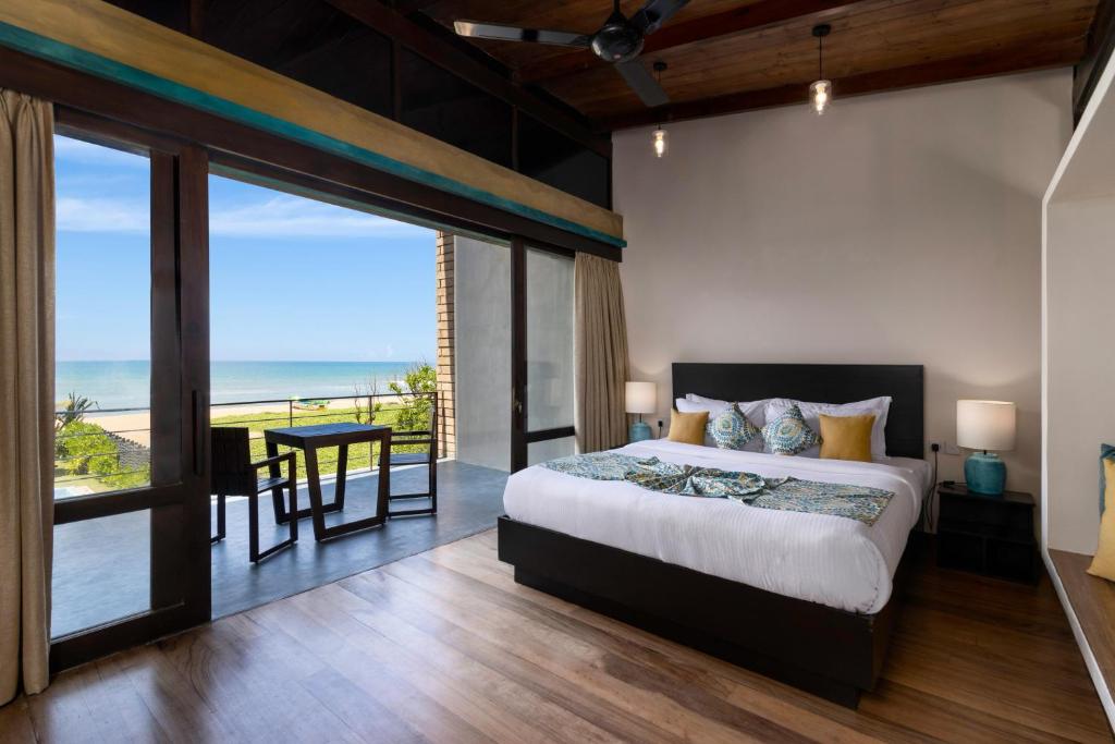 a bedroom with a bed and a view of the ocean at Inidi Leisure Luxury Villas in Wadduwa