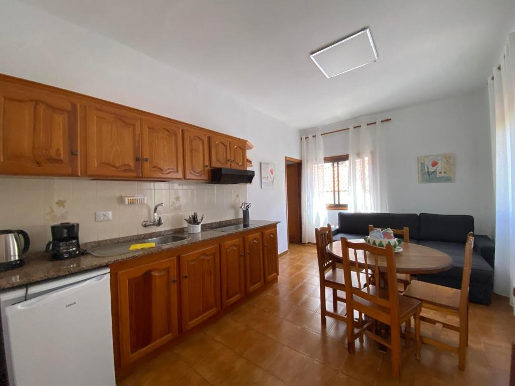 a kitchen with wooden cabinets and a table and a dining room at Apartamento Nelly A2 in Valle Gran Rey