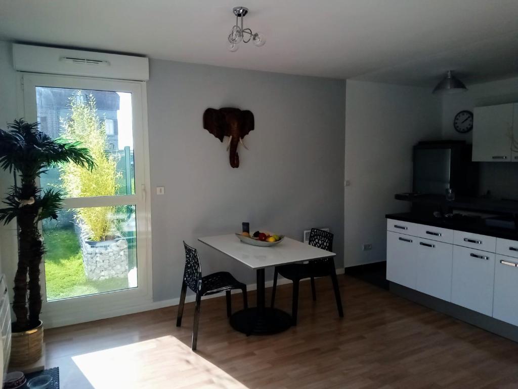 a kitchen with a table and chairs and a window at résidence la clairière aux portes de la baie de Somme in Abbeville