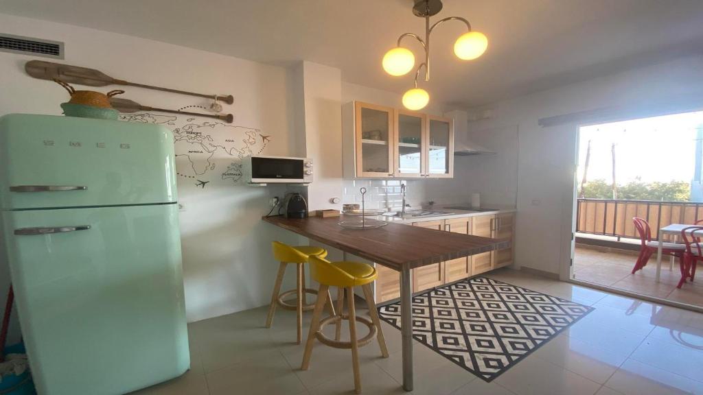 a kitchen with a refrigerator and a table with chairs at Apartamento La Ola in Valle Gran Rey