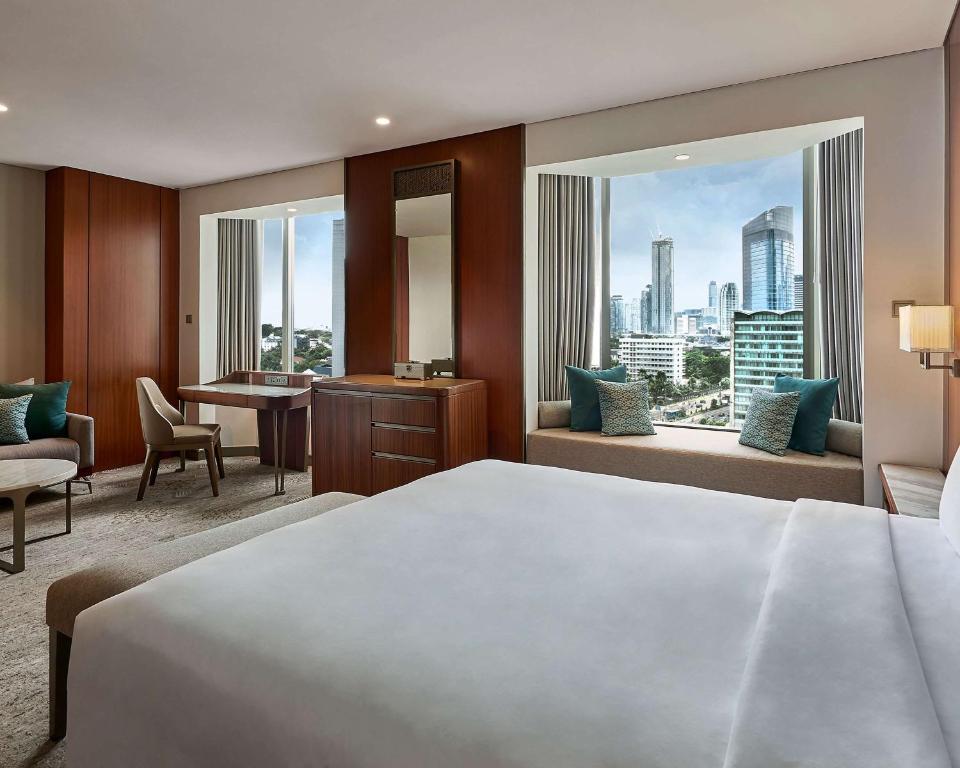 a hotel room with a large bed and a desk at Grand Hyatt Jakarta in Jakarta