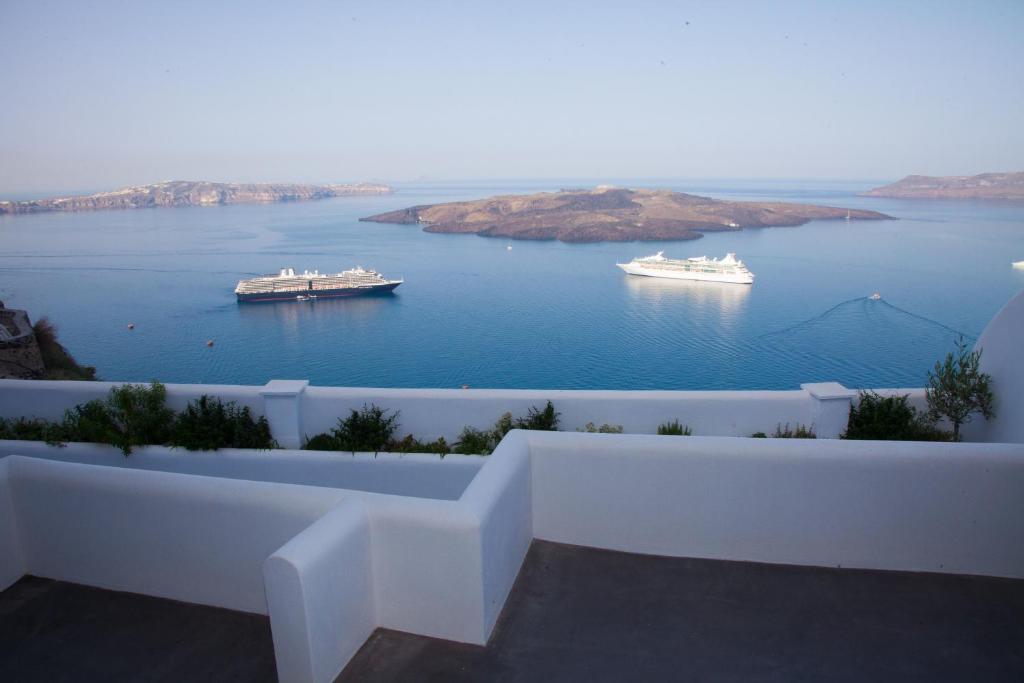 a view of a large body of water with two ships at Fanari Vista Suites in Fira