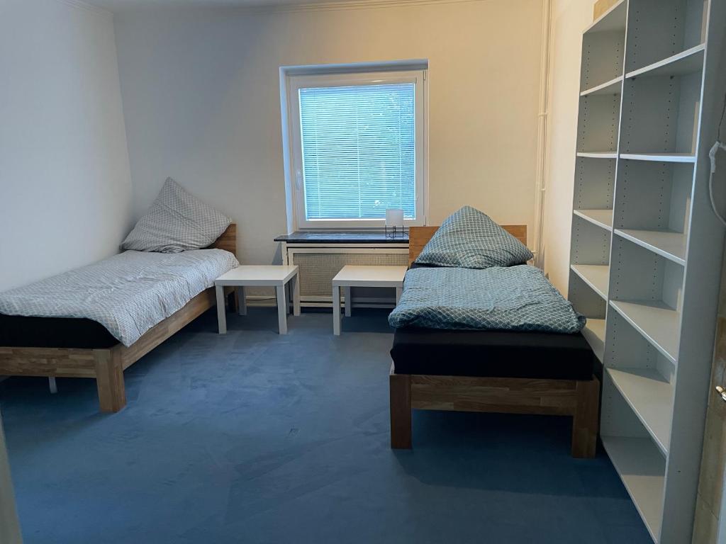 a room with two beds and a desk and a window at Wohnung 4 Zi Küche 2 Bad 4-12 P Hamburg mykojede in Braak
