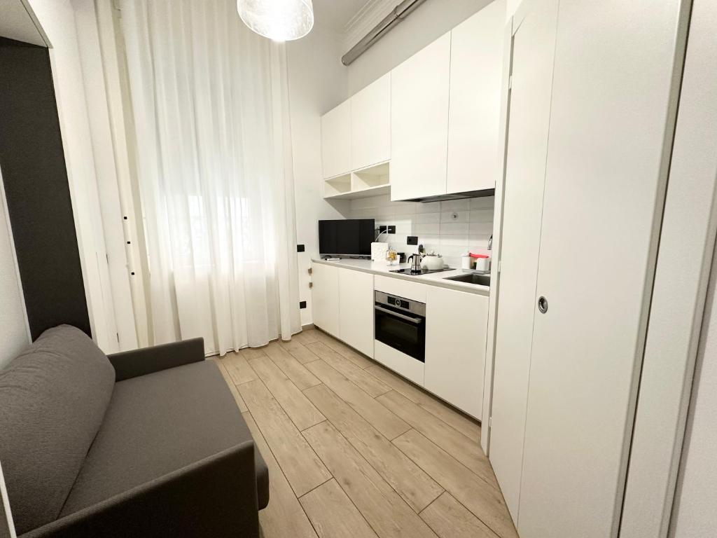 a living room with a couch and a kitchen at Small house near the Station in Milan