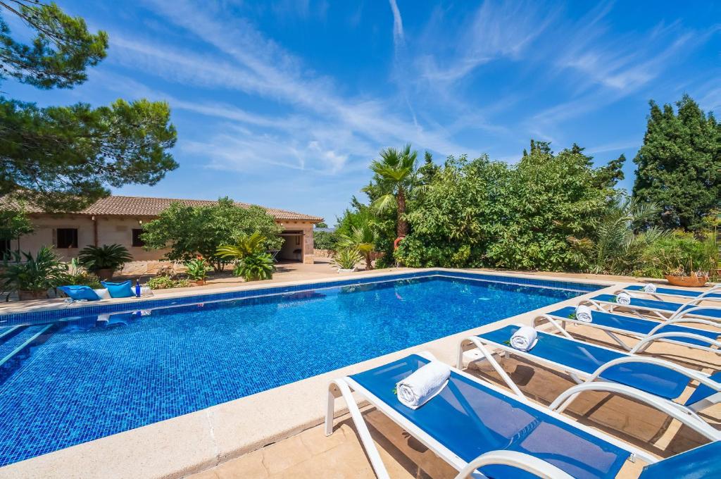 a swimming pool with lounge chairs in a yard at Ideal Property Mallorca - Can Ribas in Can Picafort