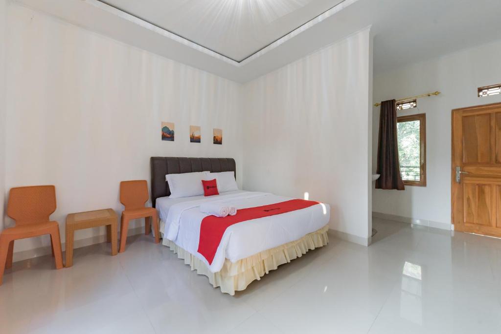 1 dormitorio con 1 cama y 2 sillas en RedDoorz near Ciletuh Sukabumi en Cilowa