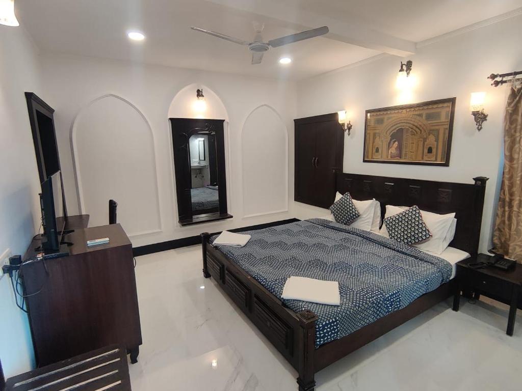 a bedroom with a bed and a flat screen tv at The Fateh Hotel by Le Pension Stays in Udaipur