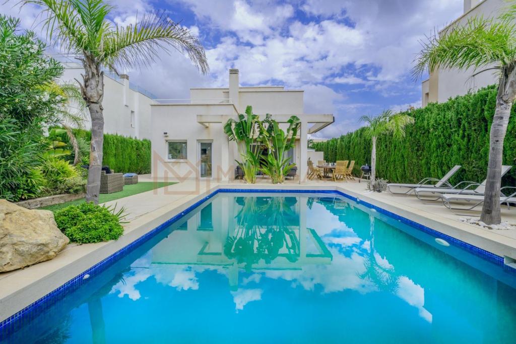 a pool in front of a house with palm trees at Four Bedroom Mimosas Villa With A Private Pool in Atamaría