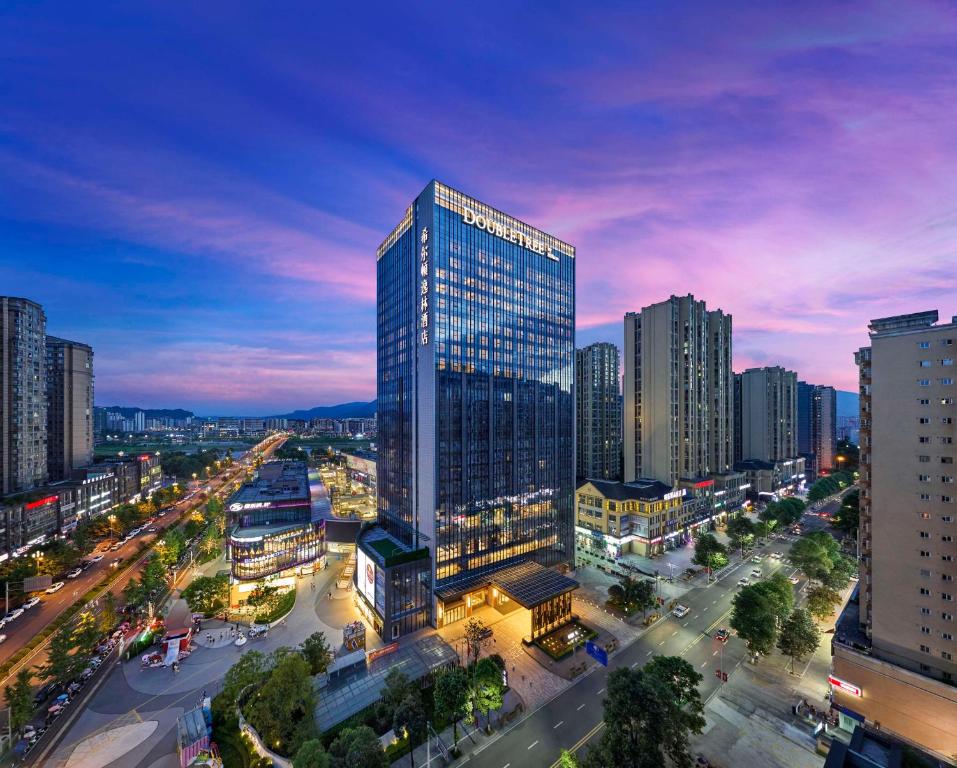 um horizonte da cidade à noite com um edifício alto em Doubletree By Hilton Ya'An em Ya'an