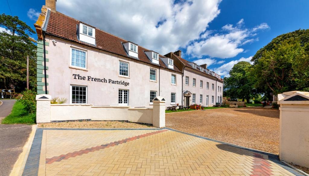 un gran edificio blanco con un cartel. en The French Partridge, en Northampton