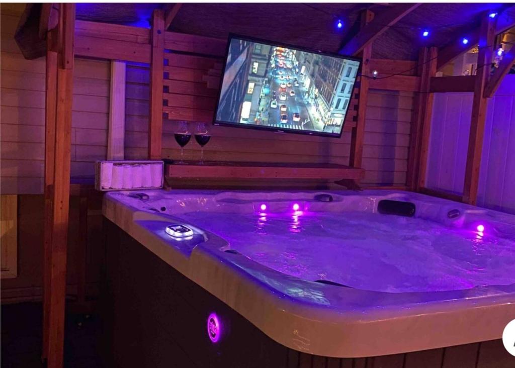 a jacuzzi tub with a tv in a room at bassement whit jackuzzi and pool in Copiague