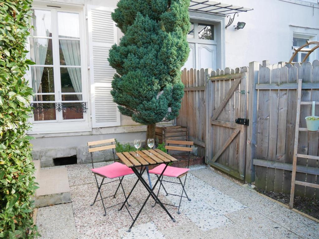 une table et des chaises devant une clôture dans l'établissement Le Petit Clos - Jardin privatif - Proche du centre, à Troyes