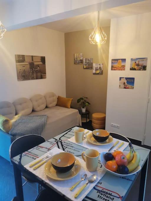 a living room with a table with bowls of fruit on it at Enjoy Lisboa! - Near Metro in Amadora