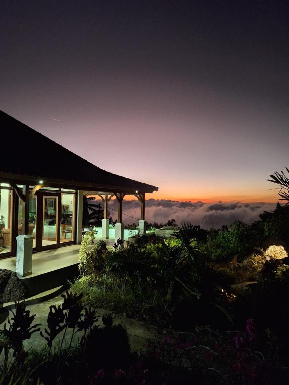 a house with a view of the ocean at sunset at Manigelang Villa in Singaraja