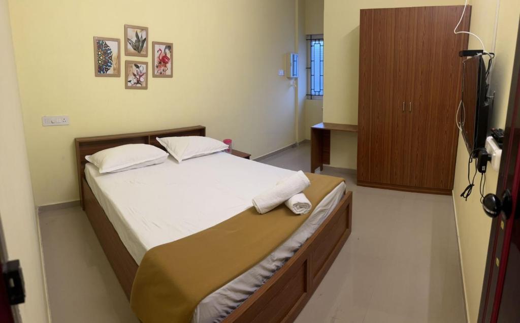 1 dormitorio con 1 cama con 2 toallas en Serene Super Deluxe Row Villa, en Karumattampatti