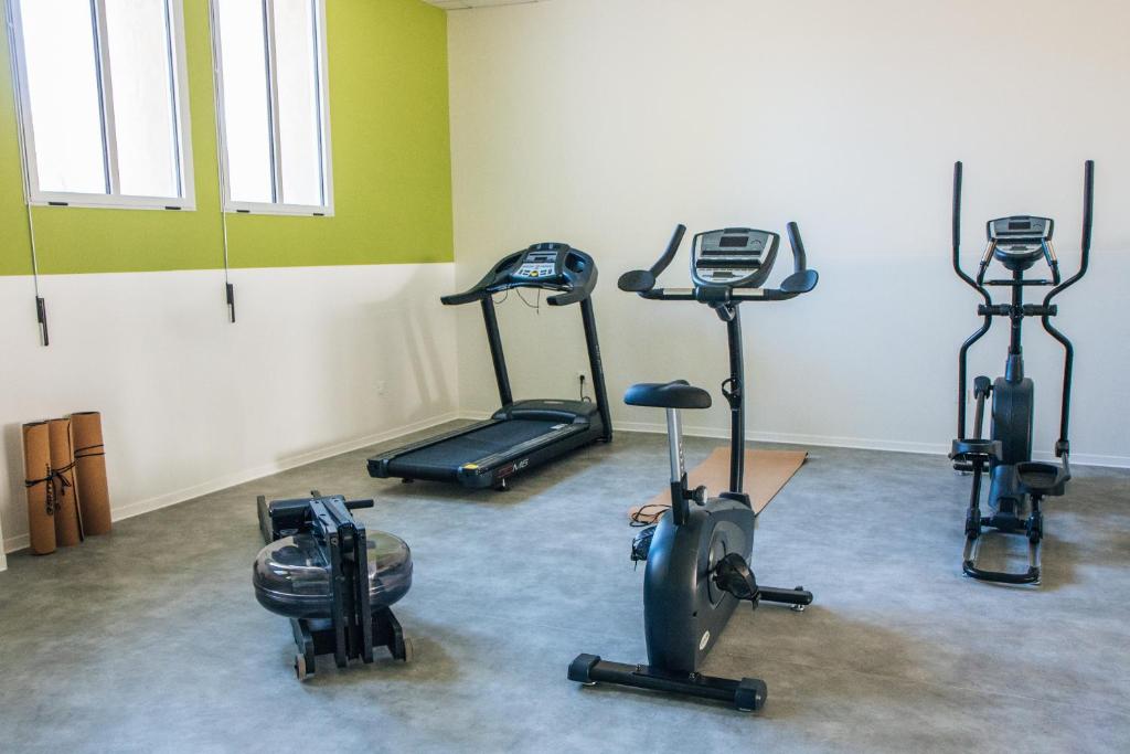 a gym with three exercise bikes in a room at Twenty Business Flats Béziers in Béziers