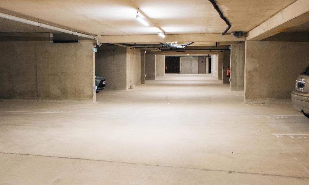 an empty parking garage with cars parked in it at Twenty Business Flats Béziers in Béziers