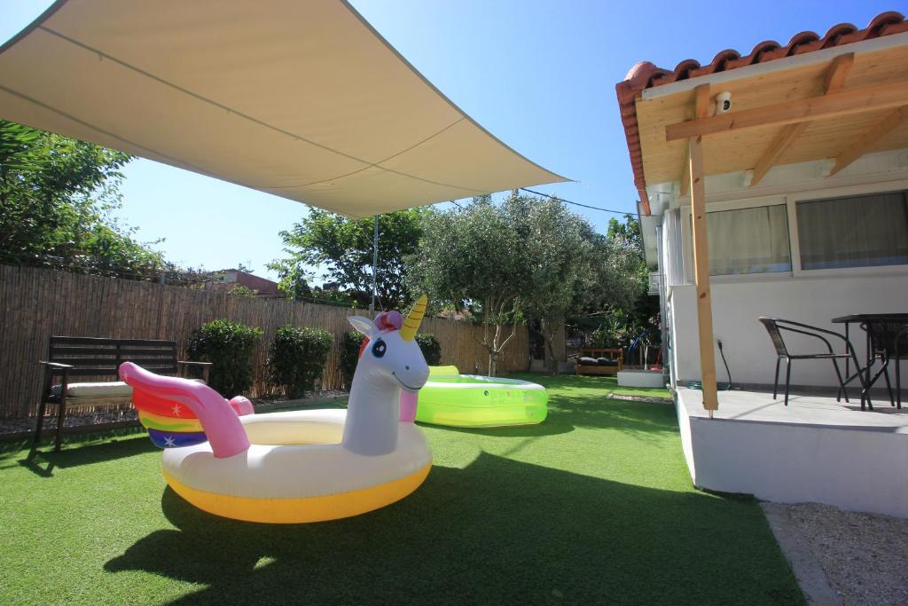 a backyard with a toy duck in the grass at Brand new house with garden, next to the beach in Áyios Ilías