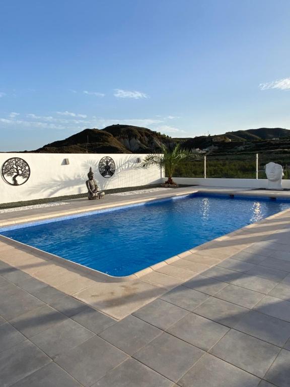 una piscina de agua azul en un patio en Casa Clara’s b&b, en Aljariz