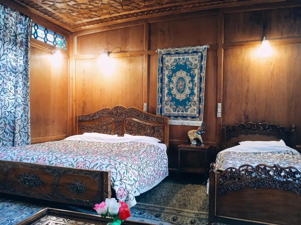 twee bedden in een kamer met houten lambrisering bij Jacqueline houseboat in Srinagar