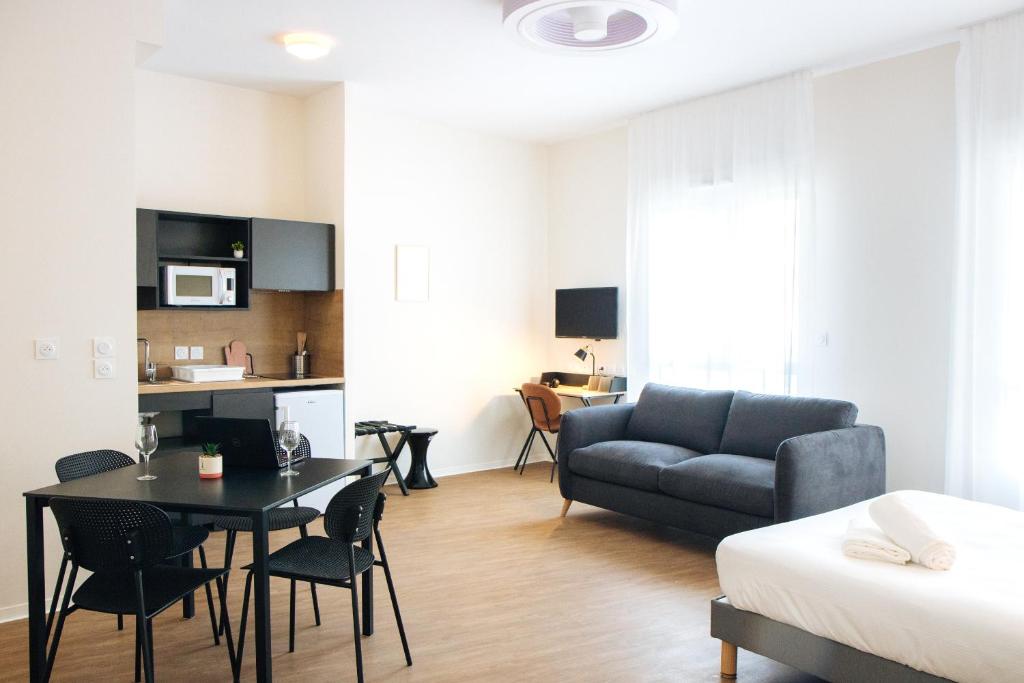 un salon avec un canapé et une table dans l'établissement Twenty Business Flats Béziers, à Béziers
