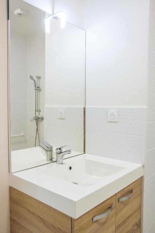 a bathroom with a white sink and a mirror at Twenty Business Flats Béziers in Béziers