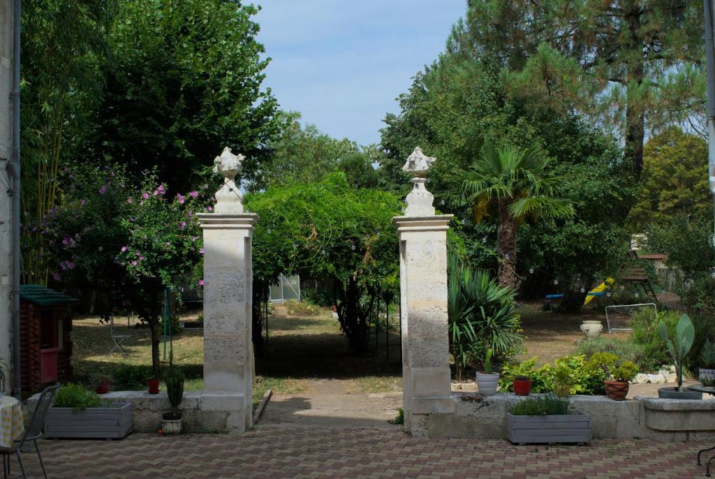 two concrete pillars in a garden with plants at Logis de Fornel in La Rochefoucauld