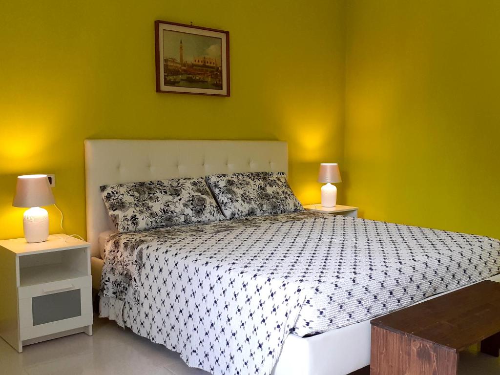 sypialnia z łóżkiem z 2 stolikami nocnymi i 2 lampami w obiekcie Casa Salera w mieście Lonato