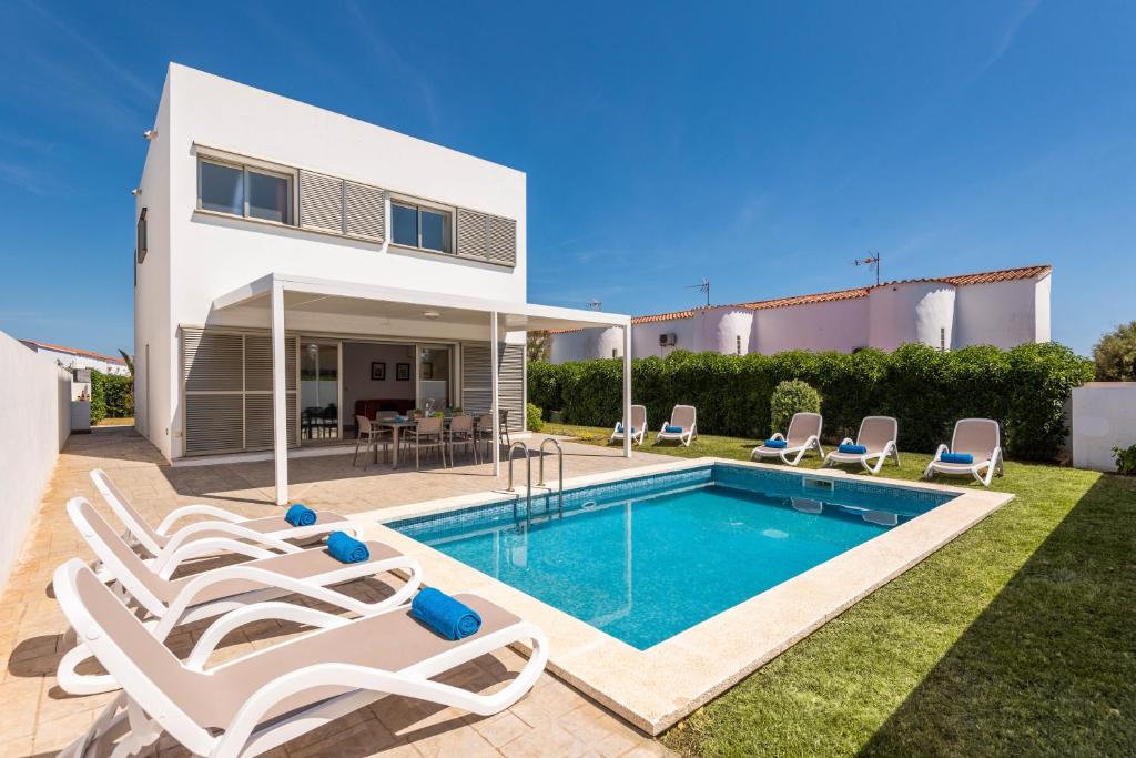 uma villa com piscina em frente a uma casa em Villa Perez em Cala'n Bosch