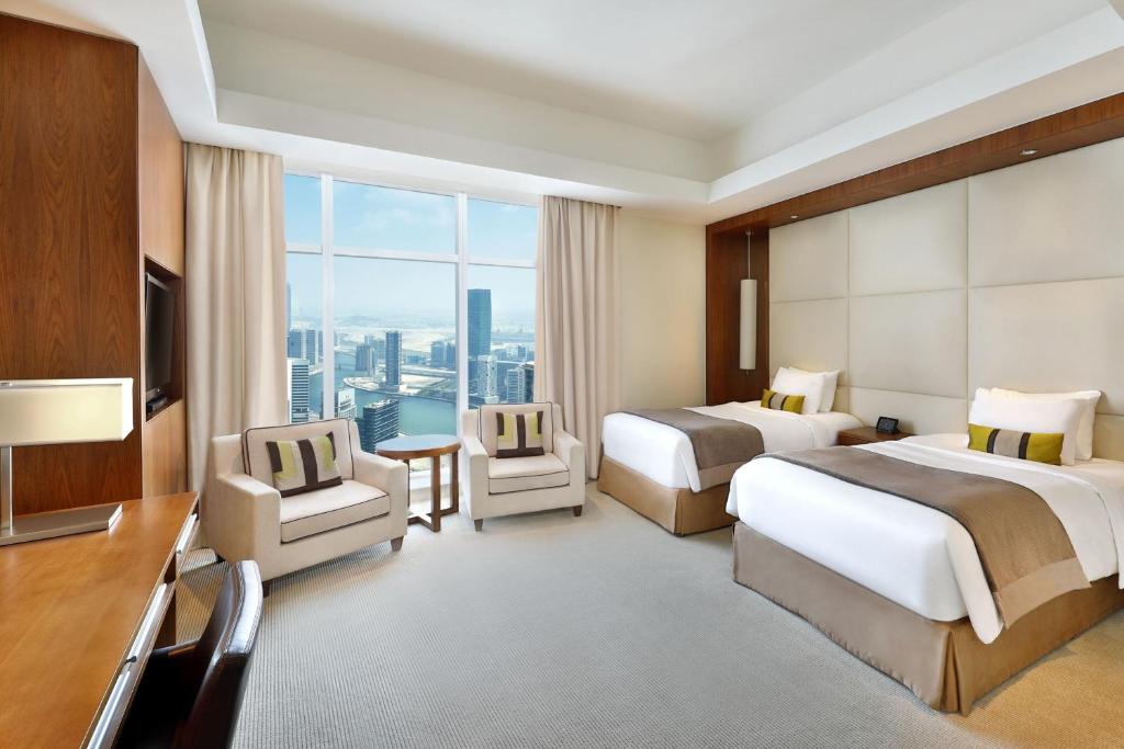 a hotel room with two beds and a large window at JW Marriott Marquis Hotel Dubai in Dubai