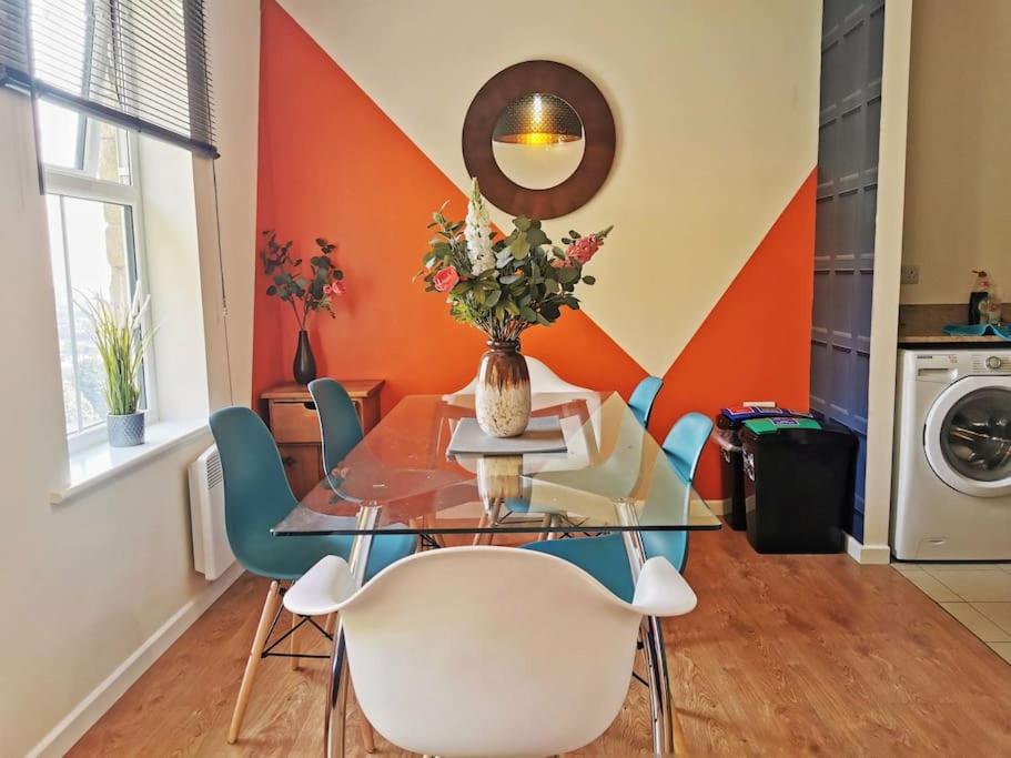 a dining room with a glass table and chairs at Fivehill Apartment, Long Stay, 4 Showers, Sleeps 10, Free Parking, in Sheffield