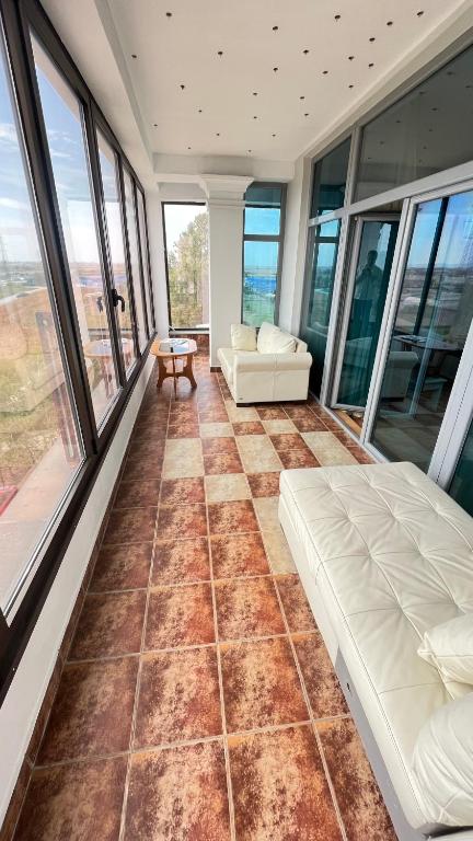 una camera con letto, divano e finestre di Sole Mio Wellness & SPA a Novi Sad