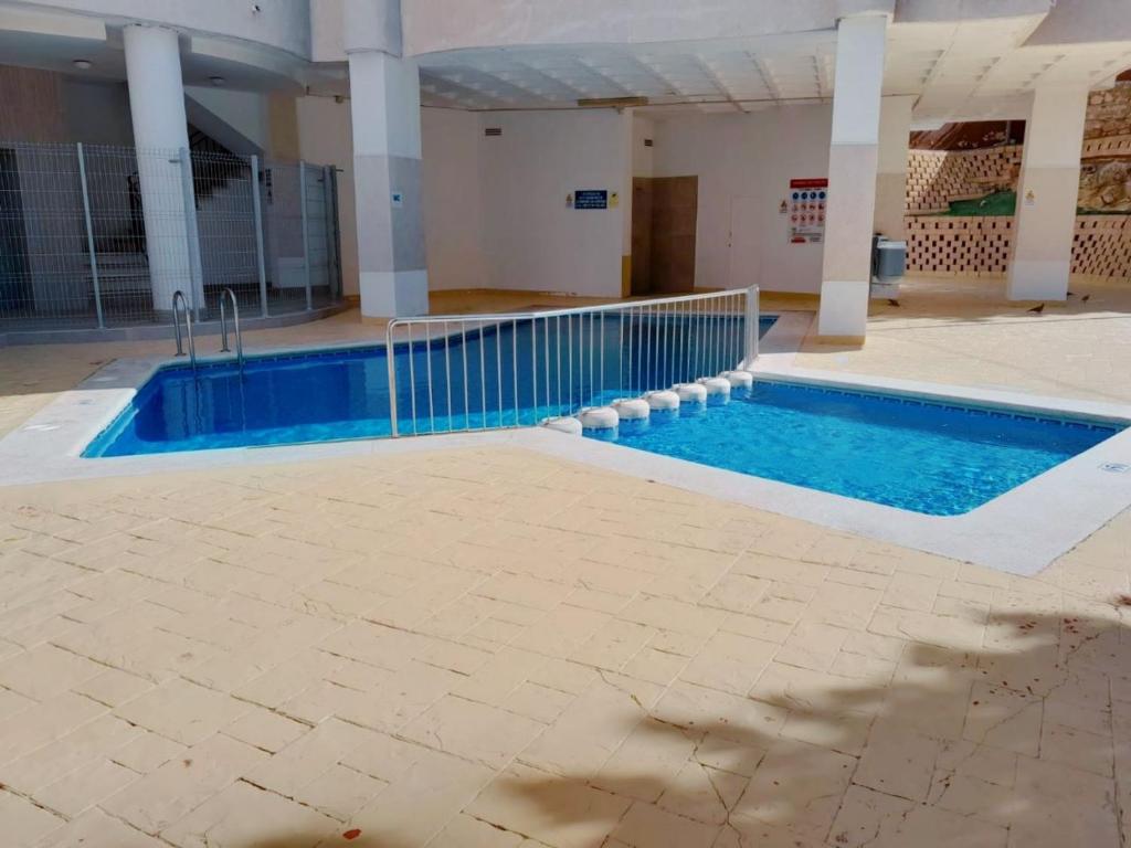 ein Pool mit blauem Wasser in einem Gebäude in der Unterkunft Las torres Alquilevante in Benidorm