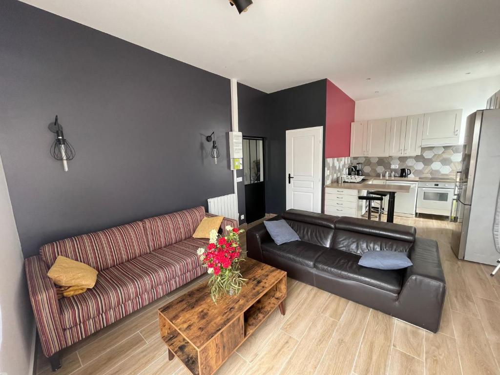 ein Wohnzimmer mit einem Sofa und einem Tisch in der Unterkunft En face du Stade de France in Saint-Denis