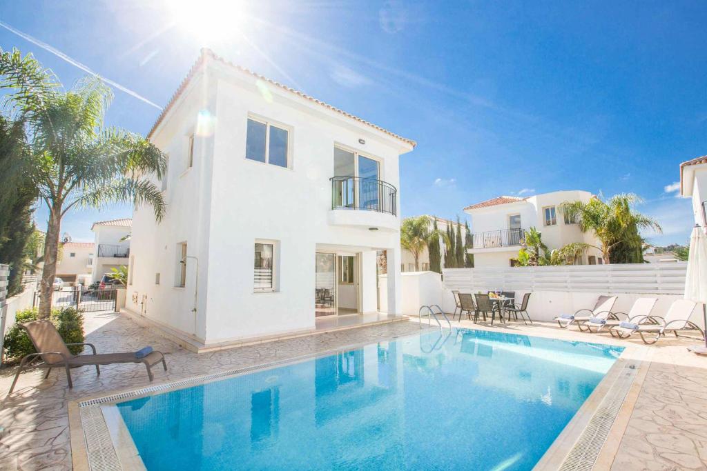 a villa with a swimming pool in front of a house at Villa Delia in Protaras