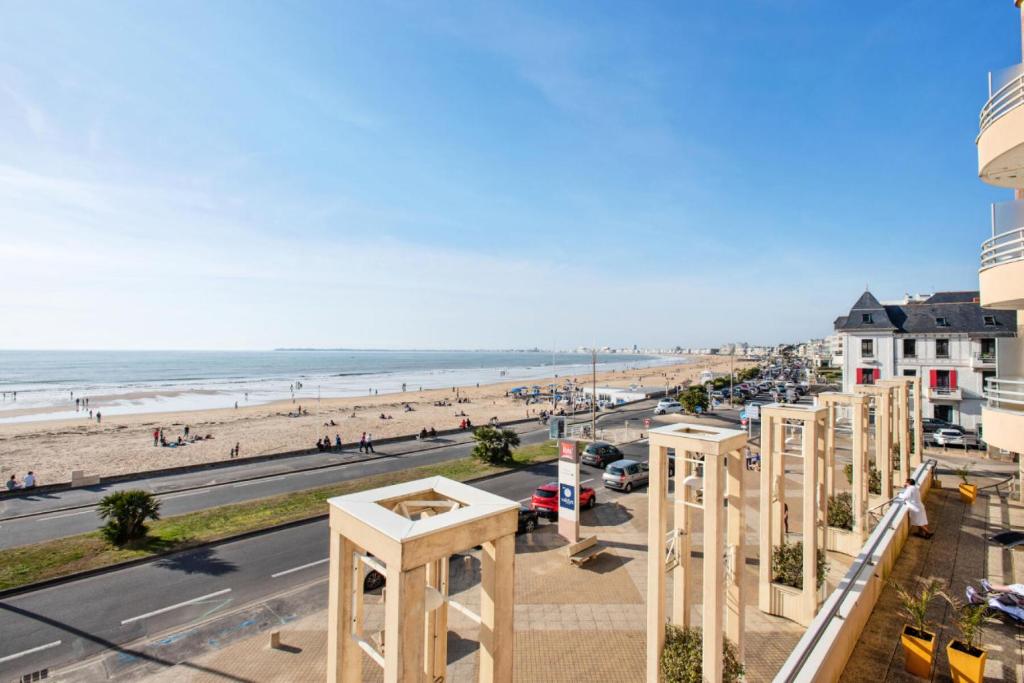 une vue sur la plage depuis le balcon d'un immeuble dans l'établissement Résidence Les Océanes - maeva Home - Studio 5 personnes Confort - vue mer MAE-3803, à Pornichet