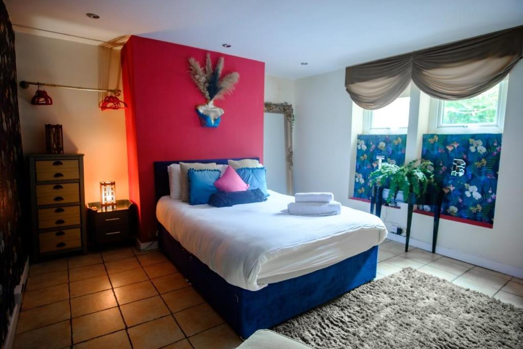 ein Schlafzimmer mit einem großen Bett mit einer roten Wand in der Unterkunft The Bunkhouse in South Shields