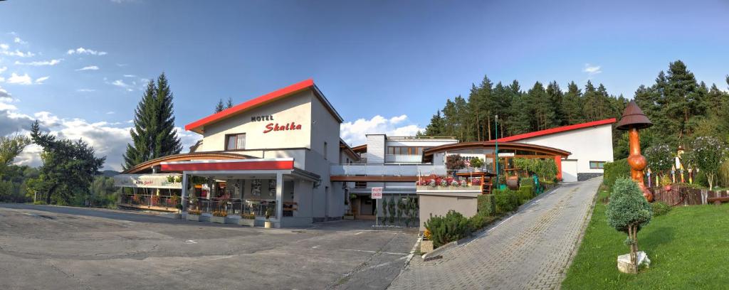 un edificio con una tienda al lado de una carretera en Motel Skalka, en Radola