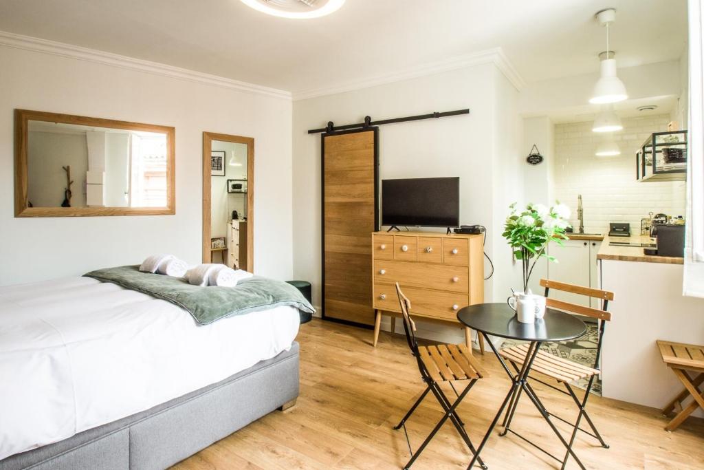 une chambre avec un lit et une table et une cuisine dans l'établissement Le Petit Capitole - Studio rénové à 2 pas du Capitole, à Toulouse
