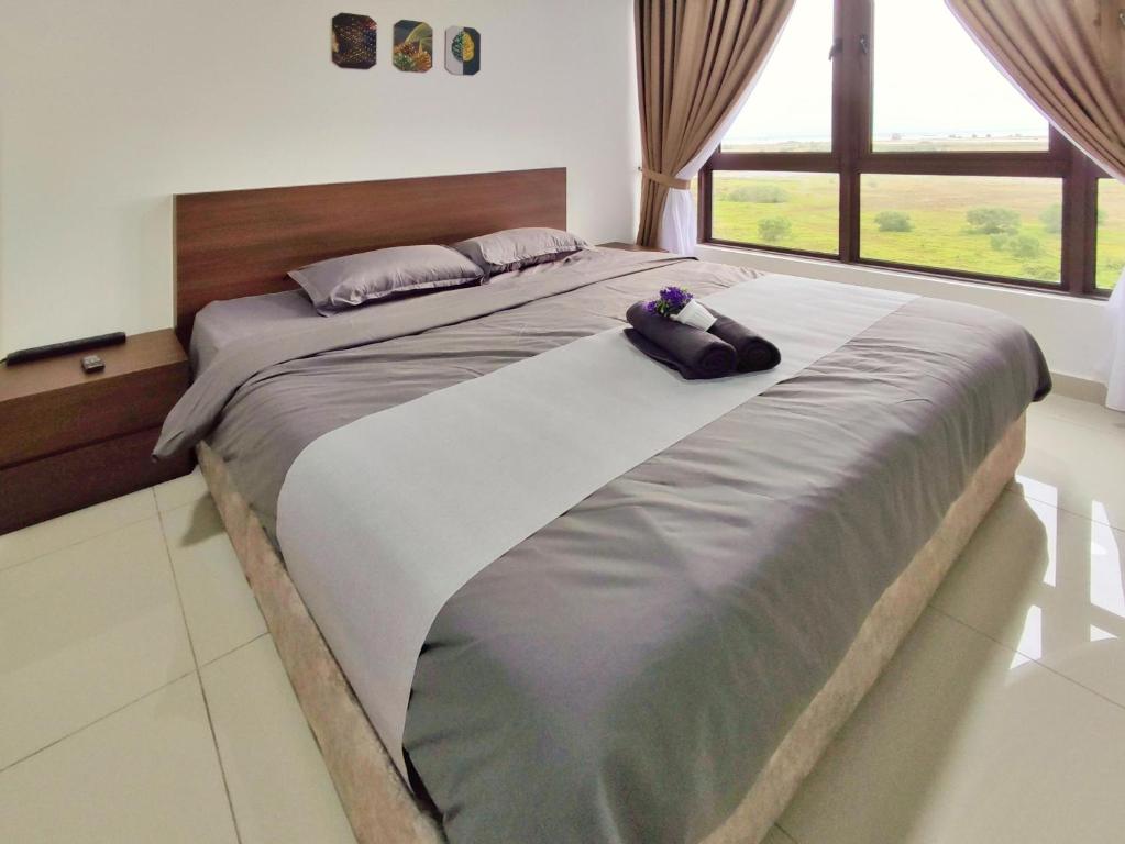 a large bed in a bedroom with a large window at Bali Residence Melaka by Jzstay 2BR in Melaka