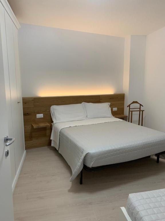 a bedroom with a large bed with white sheets at Appartamento Alpi Retiche in Morbegno