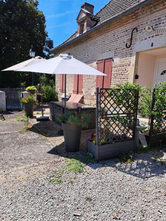 a patio with an umbrella next to a building at Gîte Le piège à rêves in Pierre