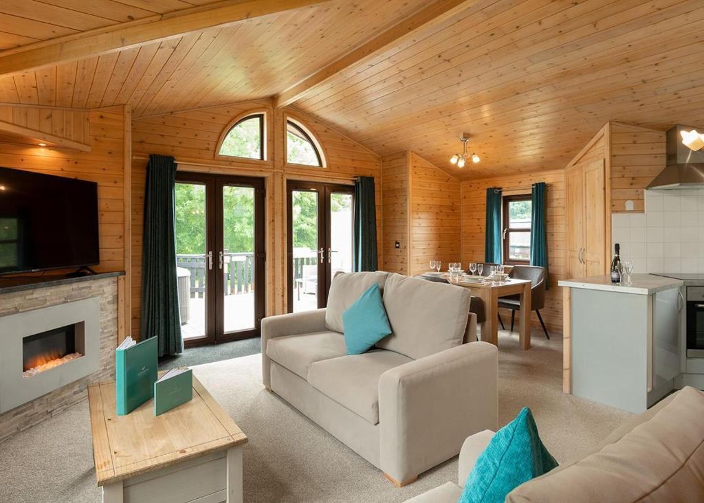 Raywell Hall Country Lodges في Skidby: غرفة معيشة مع أريكة وطاولة