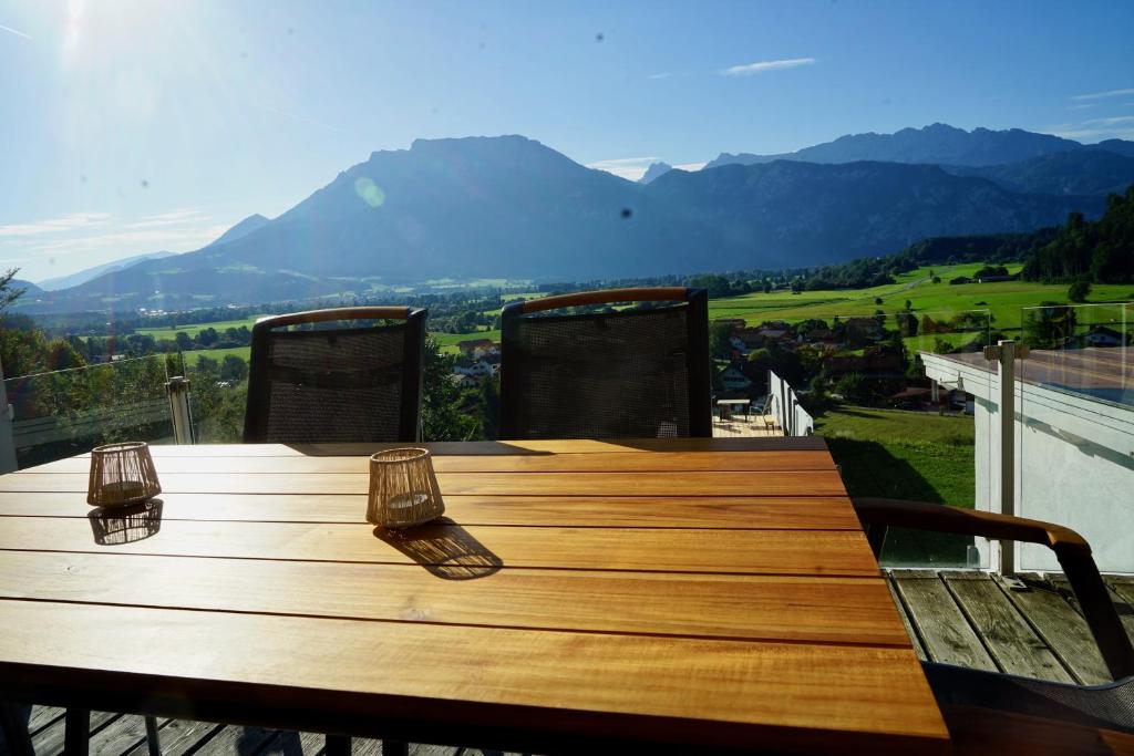 una mesa de madera en un balcón con montañas en el fondo en Grafenburg, Residenz Bayern, en Kiefersfelden
