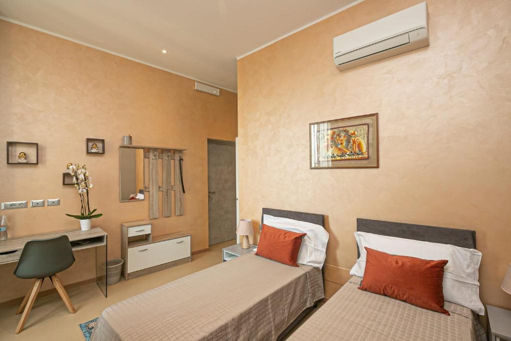Habitación de hotel con 2 camas y escritorio en Affittacamere Gioiello, en Génova